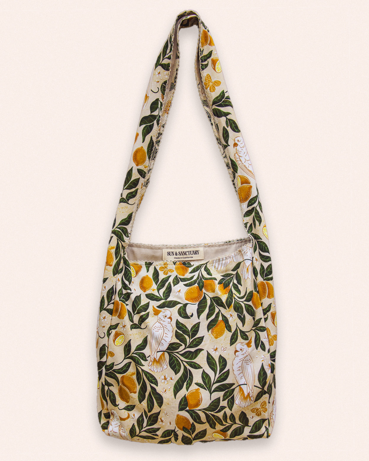 A boho style large hobo tote bag with a lemon, leaves, and cockatoo print.