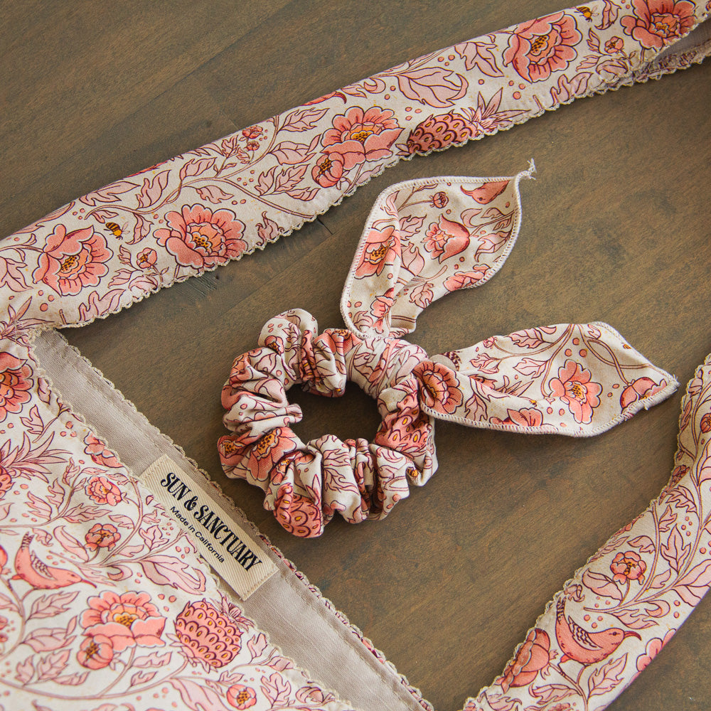 A handmade tote bag with a matching scrunchie in a pink flower print. 