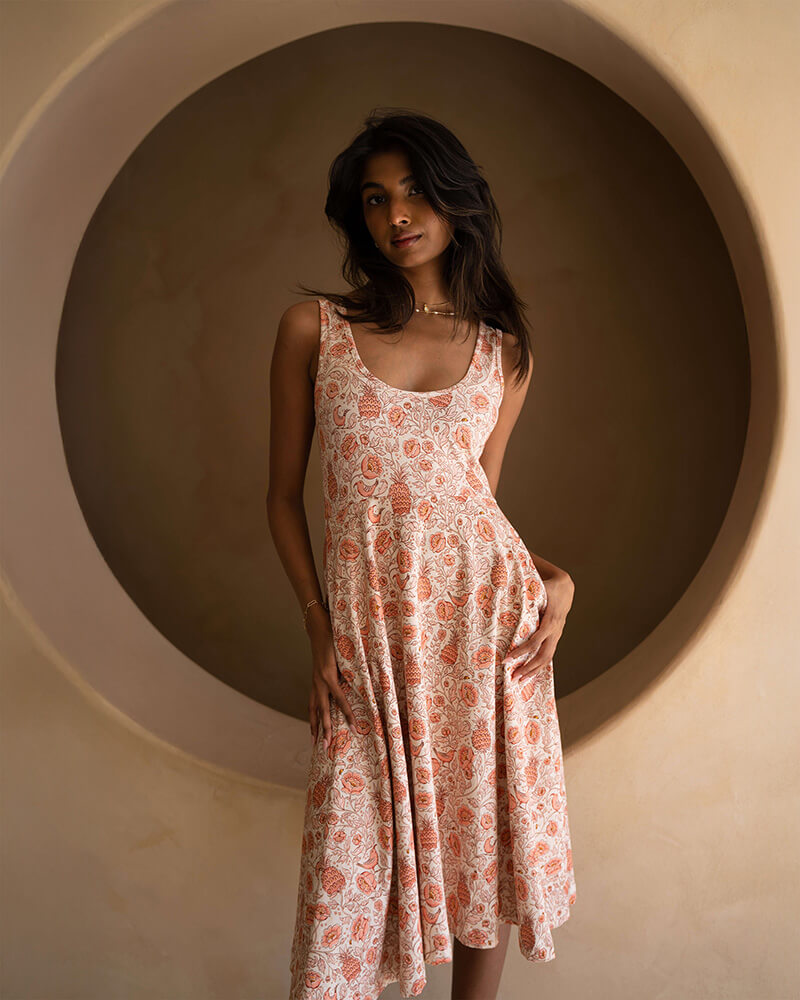 A cute fit and flare dress with tank top sleeves for spring and summer fashion. It features a pink and beige all over print. 