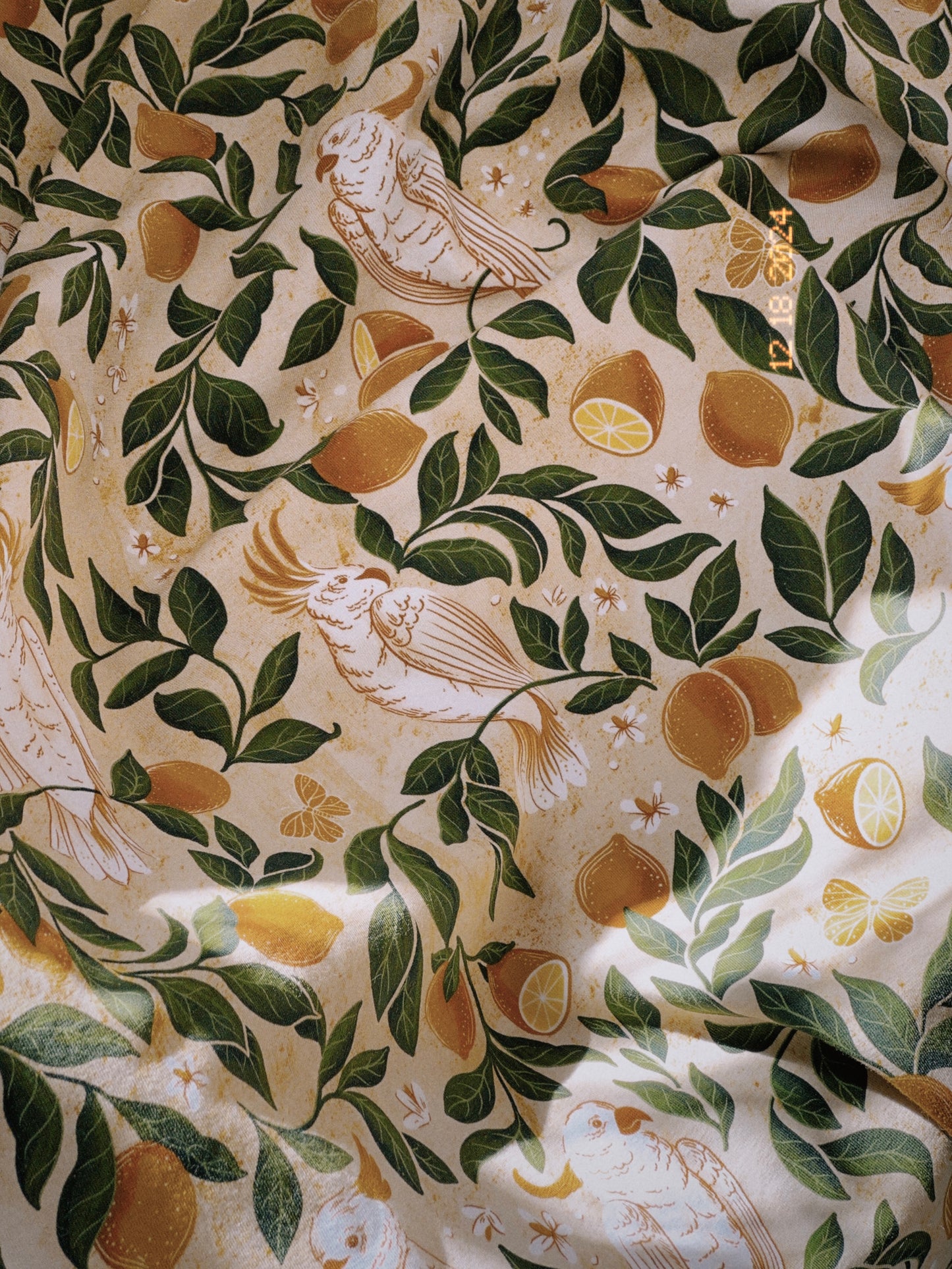 A heavy, sumptuous cotton jersey fabric printed with painterly leaves, lemons, and tropical birds. 