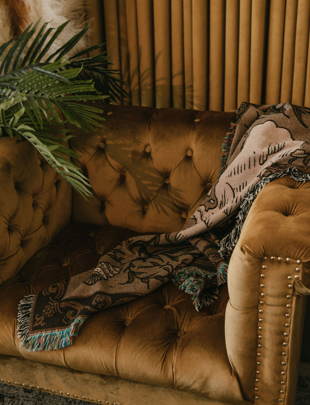 A nautical woven tapestry throw blanket draped over an armchair for elegant home decor.