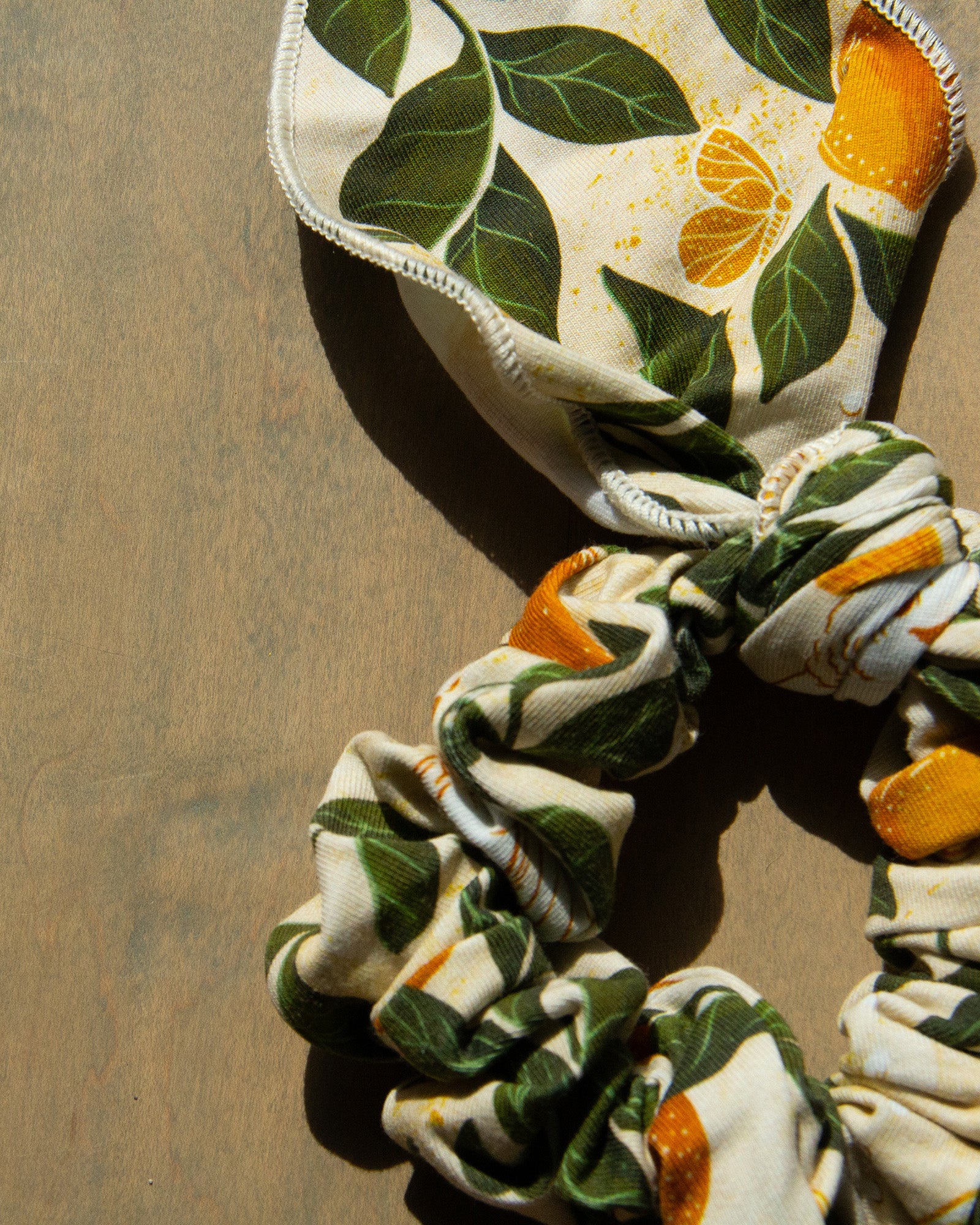 Colorful printed lemon, leaf, and butterfly fabric on a women's hair tie accessory. 
