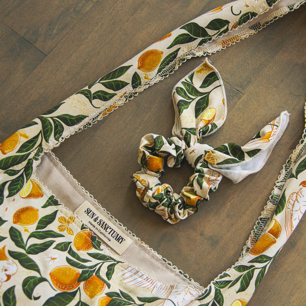 Women's tote bag with lemon and leaf pattern and matching scrunchies on a wooden surface, featuring a bohemian brand label.