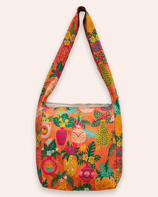 Colorful shoulder bag with tropical flower, bird, and palm leaves pattern.
