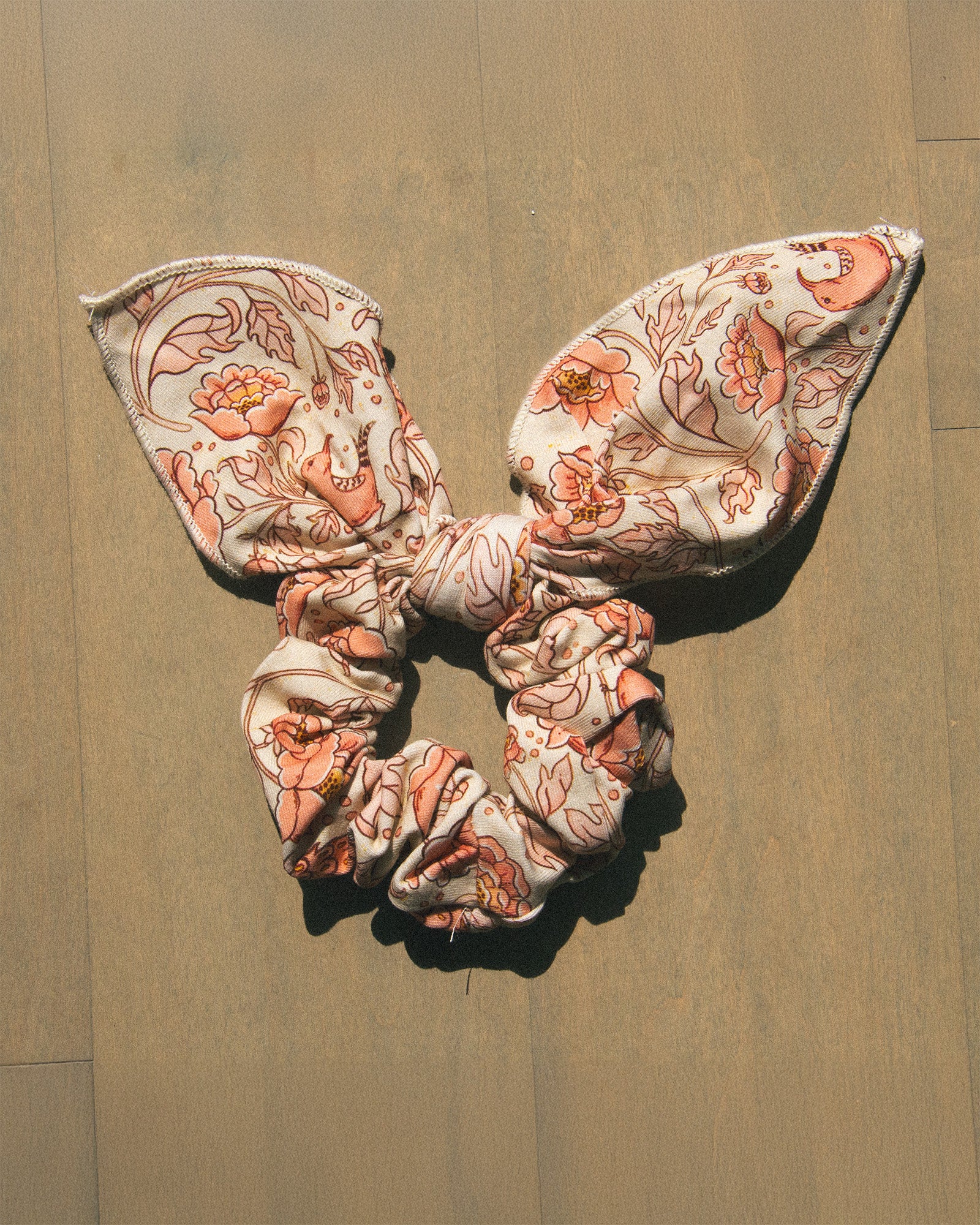 A pastel pink and beige floral scrunchie. 